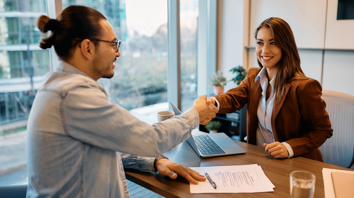 Consultant en recrutement prenant des notes attentivement pendant l'explication des besoins de recrutement par un client